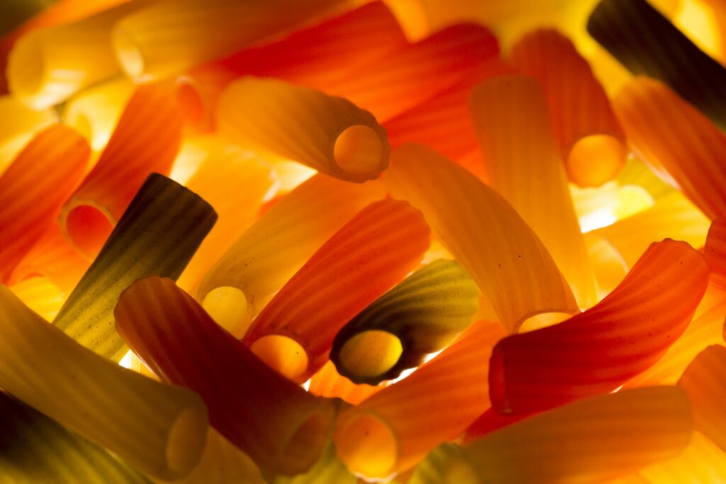 pexels-photo-221115-221115 Vibrant close-up of colorful pasta illuminated with warm light.